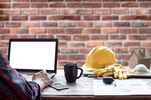 construction man working on a laptop at his desk